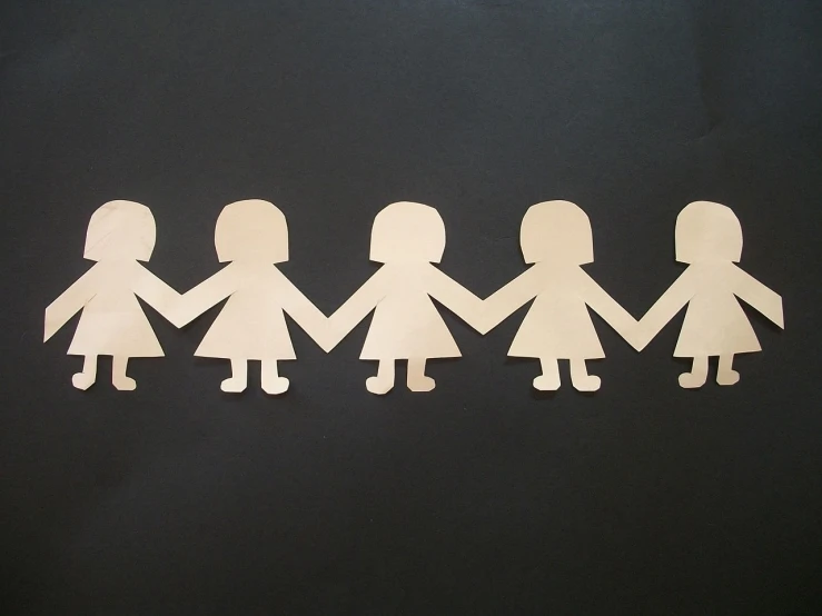 a group of cut out paper people holding hands, a picture, by Almeida Júnior, pixabay, folk art, young girls, on black paper, lined up horizontally, 7 0 s photo