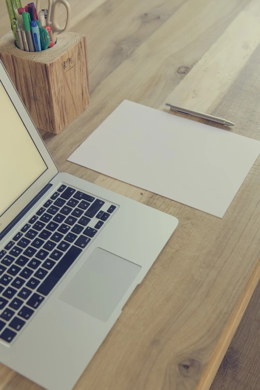 a laptop computer sitting on top of a wooden desk, pexels, computer art, blank paper, background image, mid shot photo