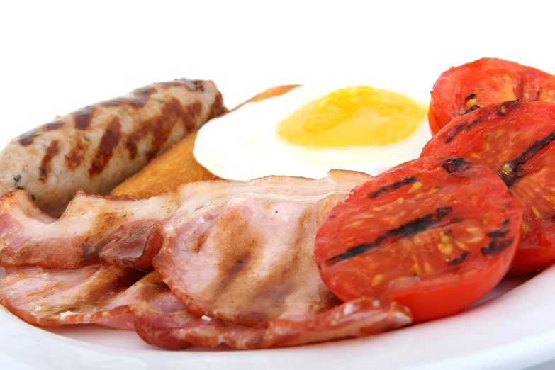 a close up of a plate of food on a table, by Julian Hatton, shutterstock, hearty breakfast, on white, anonymous as a sausage, reds