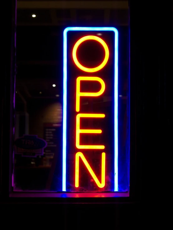 a close up of a neon sign in a window, a stock photo, by Matt Cavotta, happening, open door, open plan, wikipedia, full length photo