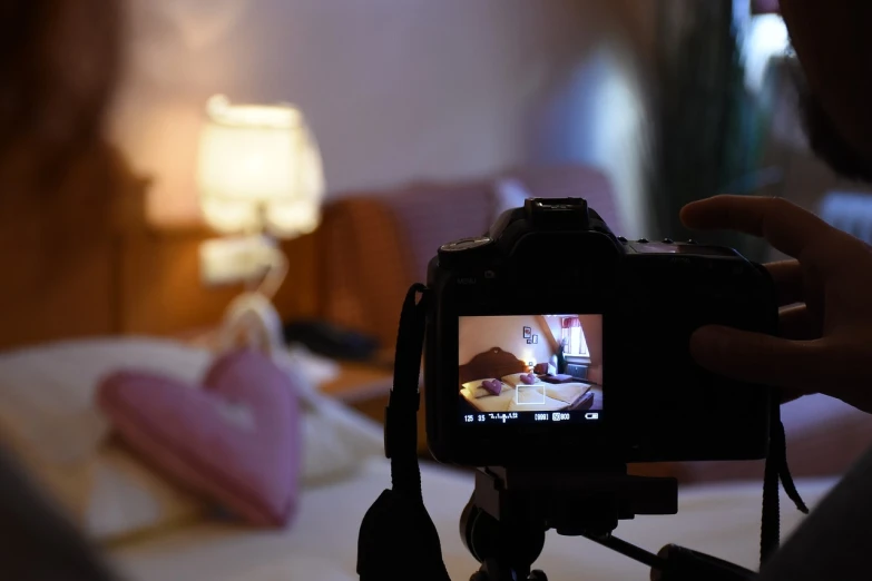 a person taking a picture of a bed with a camera, inspired by Nan Goldin, pixabay, video art, food commercial 4 k, night shot, soft light 4 k in pink, low angle photo