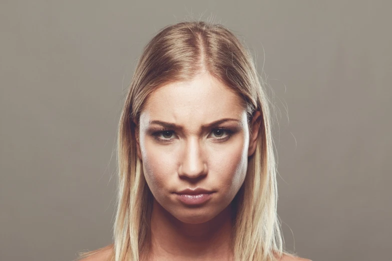 a woman with a serious look on her face, shutterstock, crazy hate face, young blonde woman, front face symmetrical, dirty face