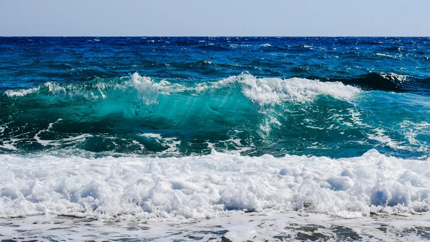 a person riding a surfboard on a wave in the ocean, a picture, azure waves of water, wallpapers, glistening seafoam, in the beach