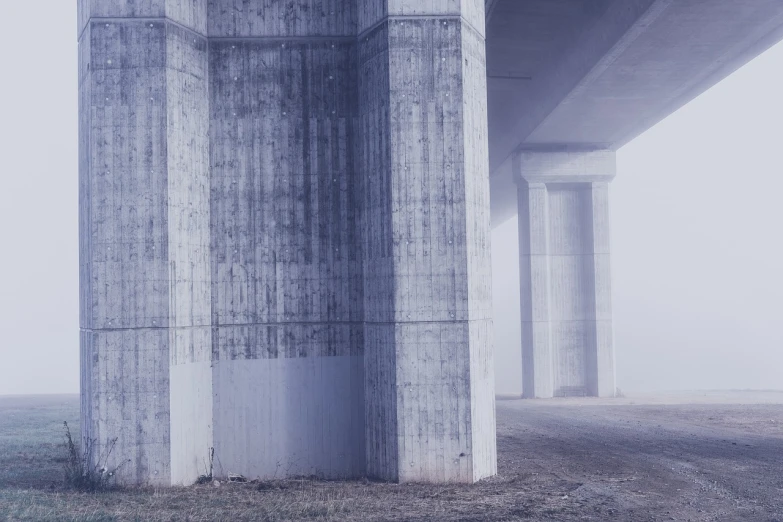 a red fire hydrant sitting under a bridge on a foggy day, a matte painting, inspired by Elsa Bleda, unsplash, postminimalism, concrete pillars, light grey mist, overpass, purple fog