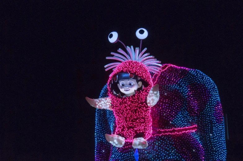 a little girl dressed up in a costume, a hologram, furry friendly monster, at nighttime, parade floats, disney 8 k photo