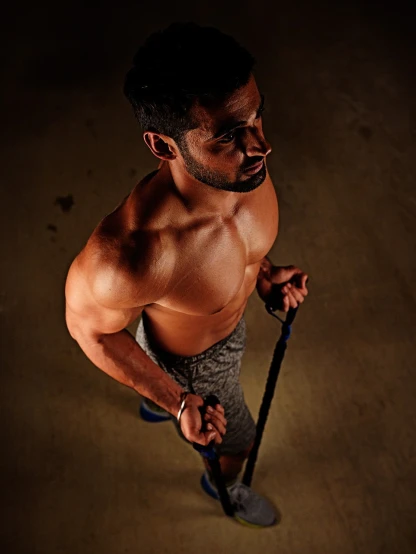 a shirtless man holding a pair of ski poles, a portrait, pexels, realism, kyza saleem, working out, 7 0 mm. dramatic lighting, top down shot