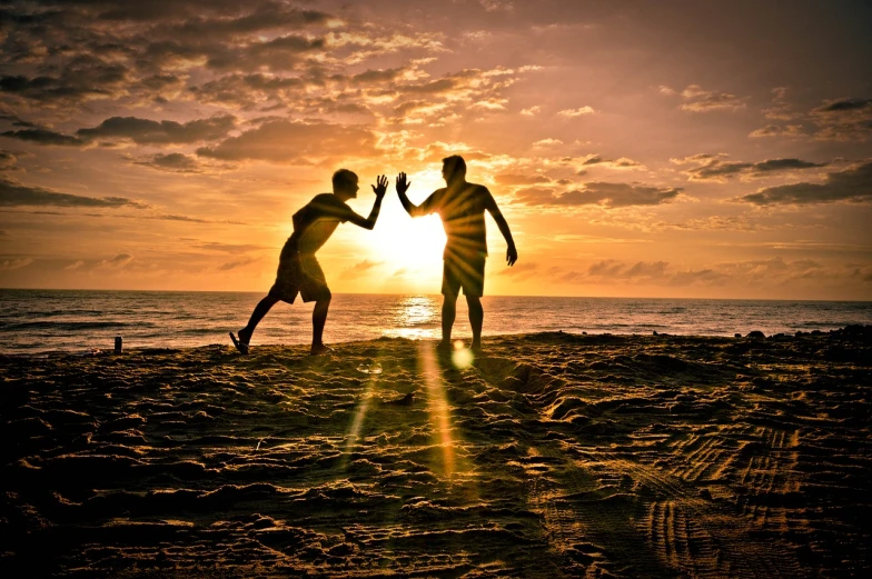 a couple of people standing on top of a sandy beach, by Matt Stewart, pixabay contest winner, hand to hand combat, praising the sun, two men, running