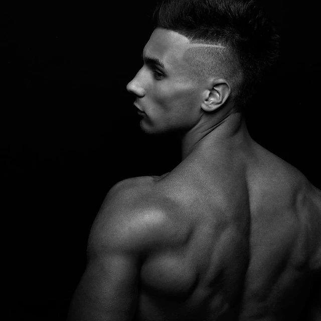 a black and white photo of a shirtless man, featured on cgsociety, profile posing, pompadour, portrait of a muscular, showing her shoulder from back