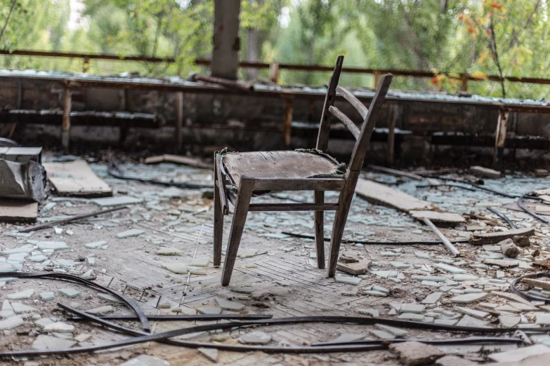 a chair that is sitting in the dirt, by Richard Carline, shutterstock, pripyat, damaged floor, stock photo, a wooden