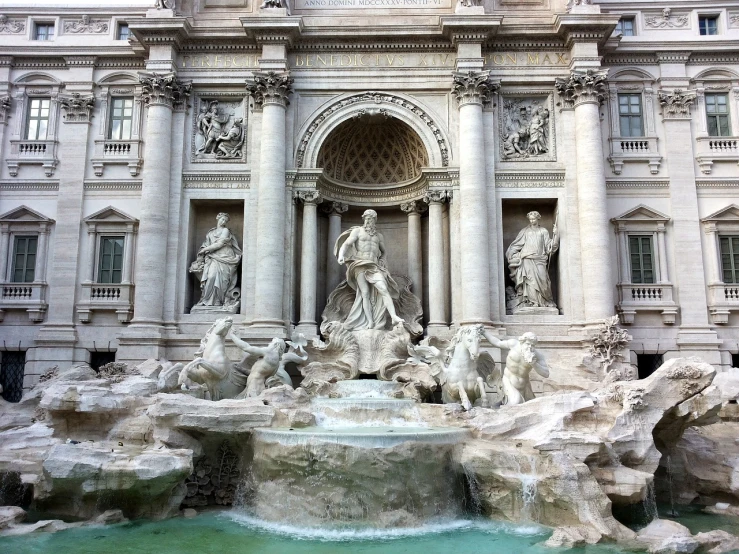 a large building with a fountain in front of it, by Gian Lorenzo Bernini, neoclassicism, cascading waterfalls, phone photo, buildings carved out of stone, tiffany