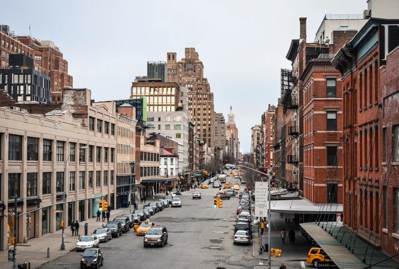 a street filled with lots of traffic next to tall buildings, inspired by Thomas Struth, pexels, new york back street, bjarke ingels, harlem, alamy stock photo