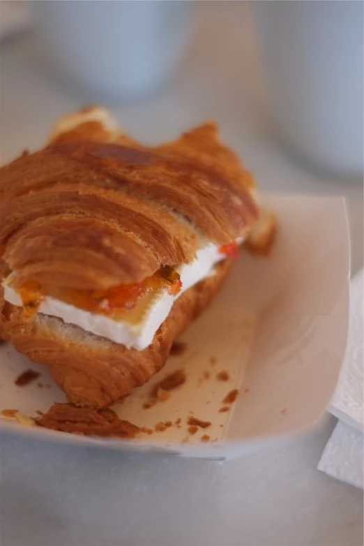 a croissant sandwich sitting on top of a white plate, a portrait, by Antonio Saura, flickr, white and orange, sicilian, :: morning, taken with a pentax1000