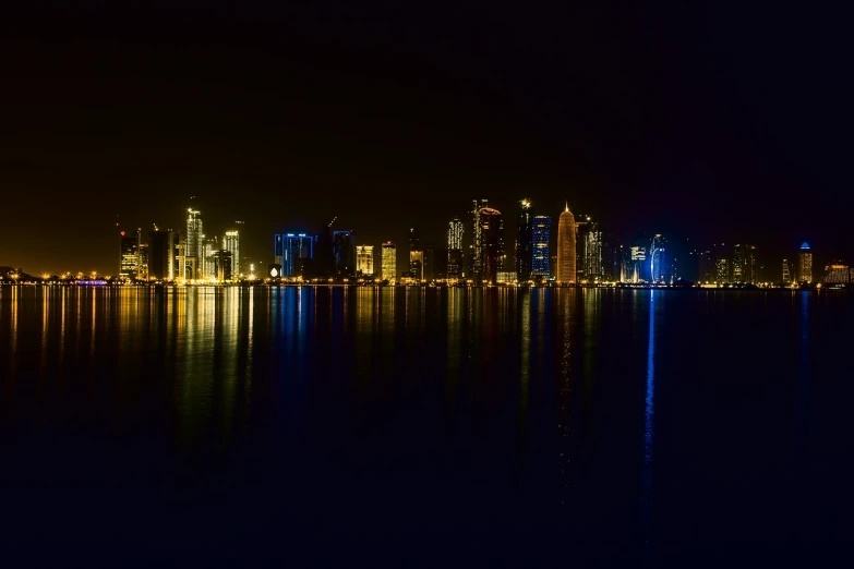 a large body of water with a city in the background, a picture, shot at night with studio lights, high res photo