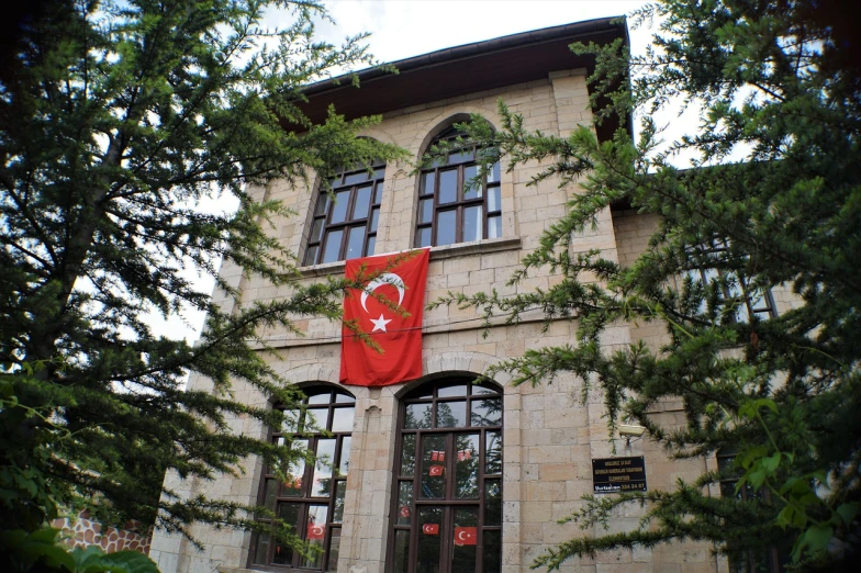 a building with a flag on the front of it, by Nevin Çokay, hurufiyya, at the museum, turkish and russian, private academy entrance, delunay