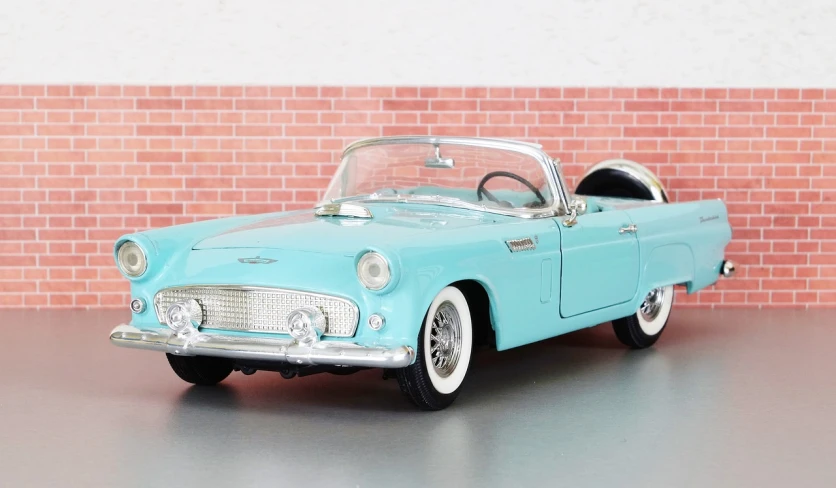 a blue toy car parked in front of a brick wall, by Harold von Schmidt, trending on pixabay, photorealism, thunderbirds, 5 0's diner, soft top, model エリサヘス s from acquamodels