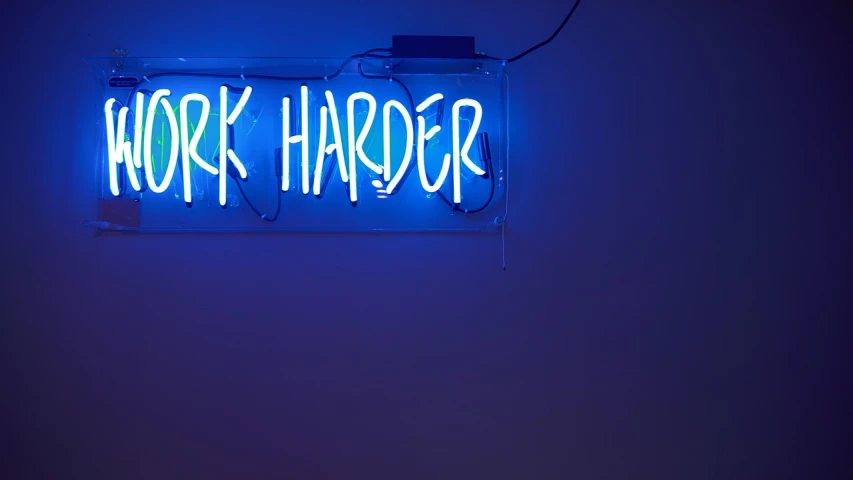 a neon sign that says work harder, by Peter Alexander Hay, dark blue, three point lighting bjork, gary, hard paint