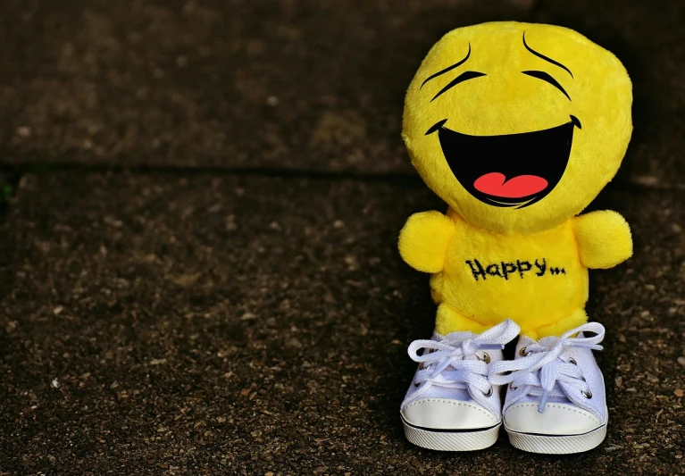 a yellow stuffed animal sitting on top of a pair of sneakers, a picture, trending on pixabay, happening, laughing emoji, amazing wallpaper, jurgen klopp laughing, smiley face