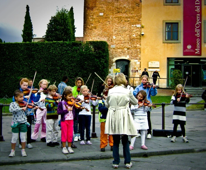 a woman teaching a group of children how to play violin, inspired by Girolamo Muziano, flickr, tourist destination, looking cute, sienna, future activist