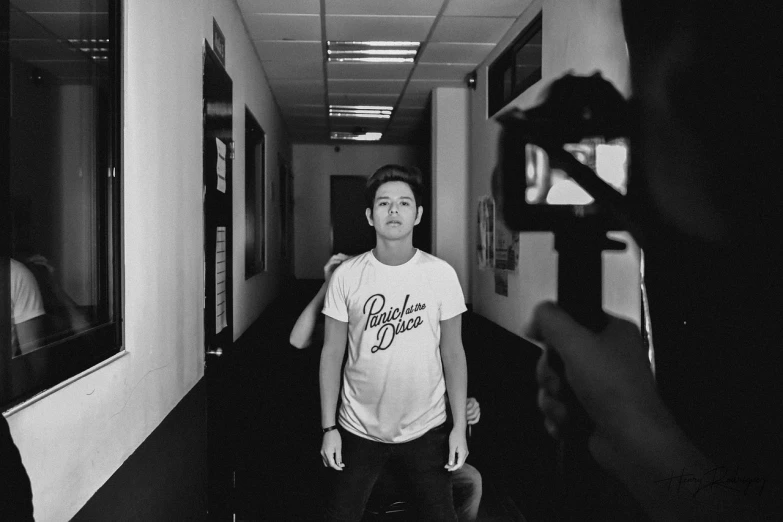 a black and white photo of a man holding a camera, by Robbie Trevino, featured on instagram, wearing a t-shirt, god emperor bongbong marcos, meet the actor behind the scenes, official music video