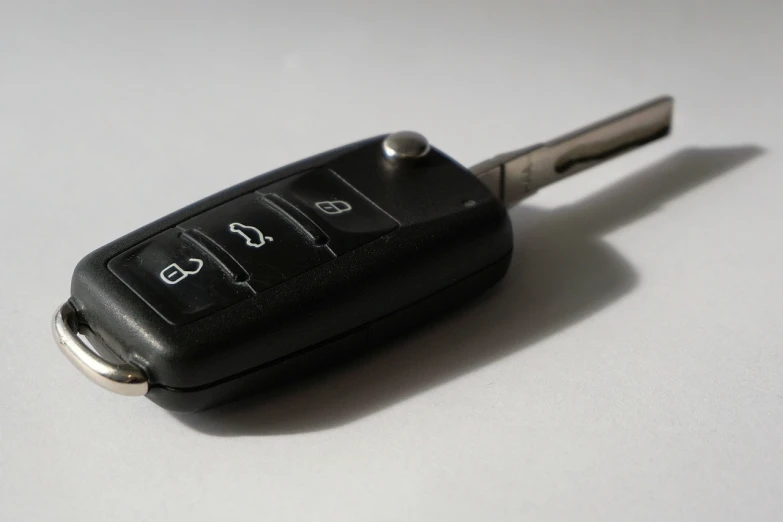 a car key sitting on top of a table, a picture, by Andrei Kolkoutine, unsplash, hurufiyya, three quarter angle, finely detailed car, black on white background, terminals