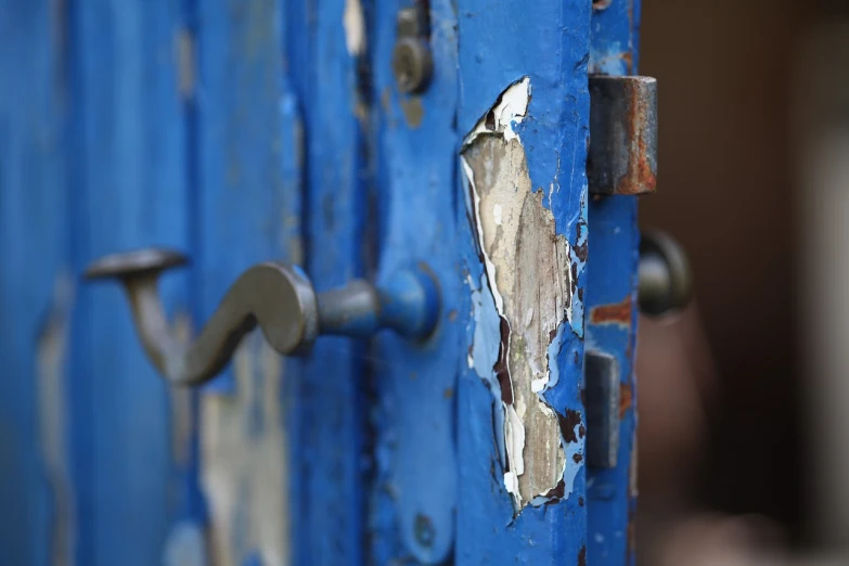 a close up of a blue door with peeling paint, by Richard Carline, happening, metal handles, broken glass photo