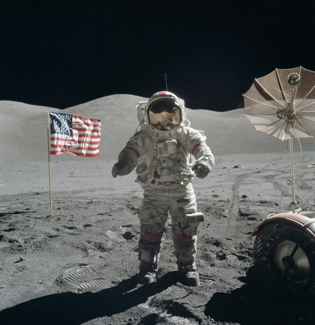 an astronaut standing on the moon next to an american flag, a colorized photo, assemblage, waving arms, stock photo, craters, wide shot photo