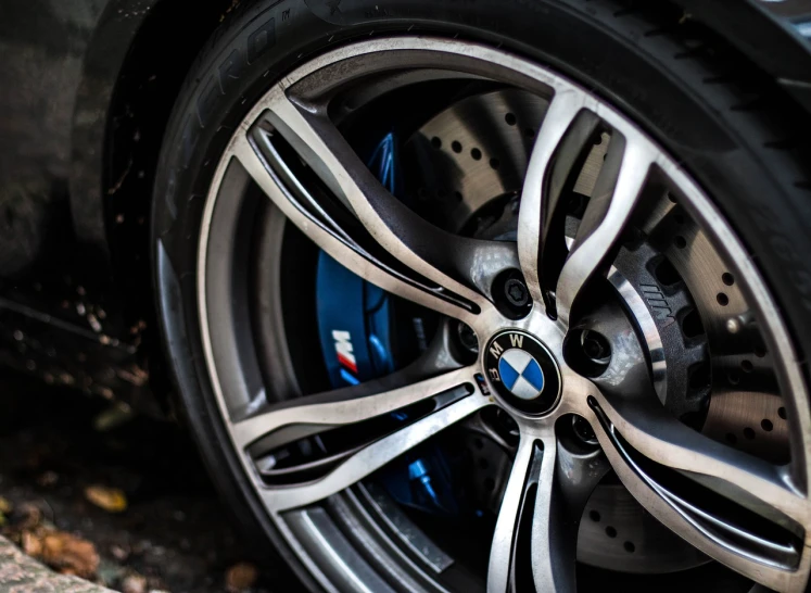 a close up of a wheel on a car, by Thomas Häfner, pexels, “2019 bmw m5 wagon, blue silver and black, accurate and detailed, colored