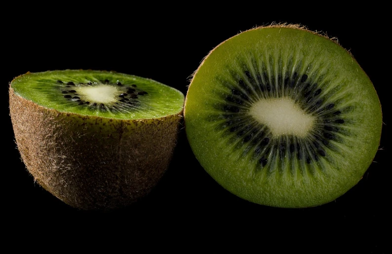 a kiwi cut in half on a black background, by Tadashi Nakayama, pexels, hyperrealistic flickr:5, green pupills, stock photo