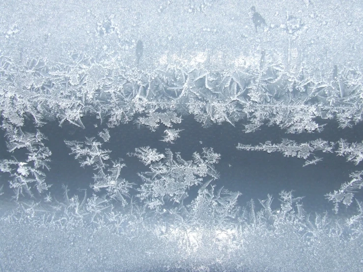 a group of snow flakes sitting on top of a window, inspired by Arthur Burdett Frost, flickr, the blue whale crystal texture, ultrafine detail ”, frozen river, intriciate detail