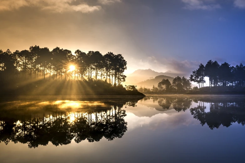 a large body of water surrounded by trees, a picture, by Etienne Delessert, pixabay contest winner, romanticism, epic sunrise, mirrored, with backdrop of god rays, national geographic photography