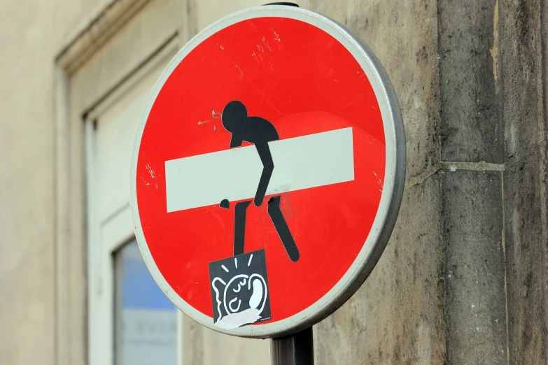 a red and white sign on the side of a building, a cartoon, pixabay, street art, subject action: holding sign, jean-sebastien rossbach, traffic signs, photograph credit: ap