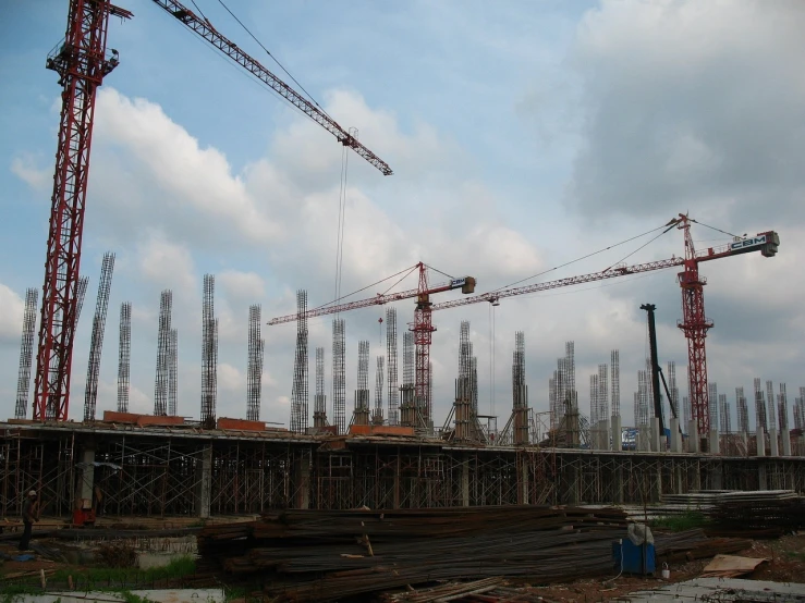 a group of cranes sitting on top of a construction site, by Susan Heidi, flickr, constructivism, jakarta, tall columns, very wide wide shot, baotou china