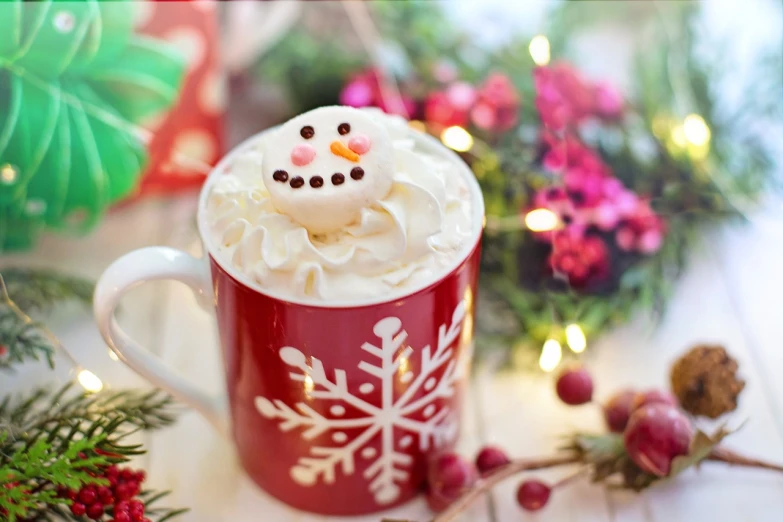 a close up of a cup of coffee on a table, folk art, winter wonderland, whipped cream on top, cute face, red and white color theme