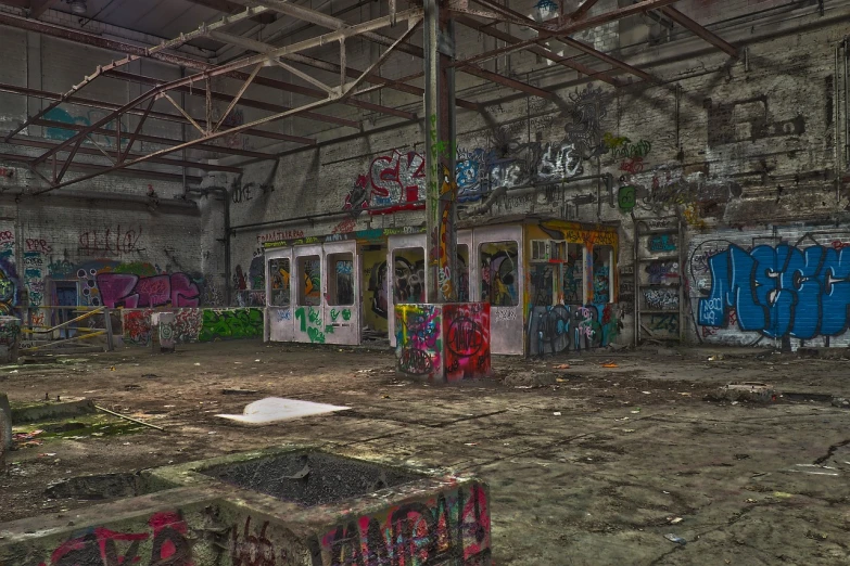 a room filled with lots of graffiti covered walls, by Richard Carline, flickr, abandoned night hangar, tram, tonemapped, sparsely populated