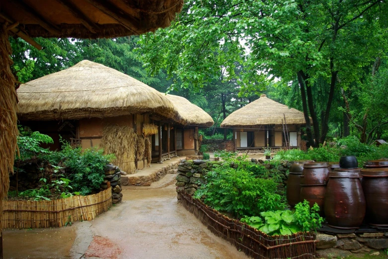 a couple of thatched huts sitting next to each other, inspired by Kim Hong-do, renaissance, ecovillage, courtyard walkway, exterior shot, woodland village