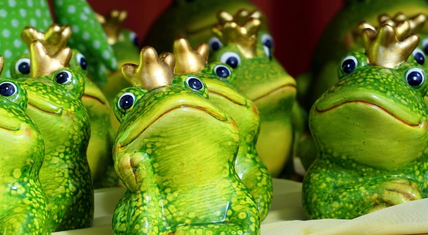 a group of frogs with crowns on their heads, by Anna Haifisch, pixabay, ceramic, wearing elaborate green and gold, closeup of arms, snacks