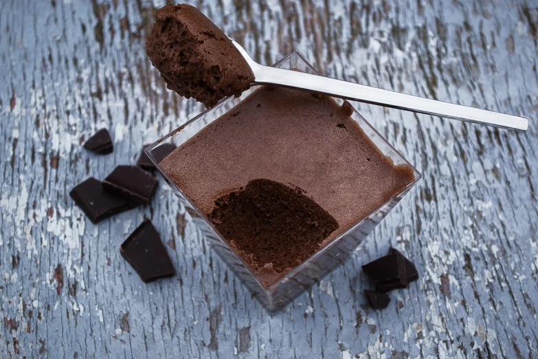 a chocolate dessert with a spoon sticking out of it, by Etienne Delessert, shutterstock, modernism, square, high quality product photo, powder, cliffside