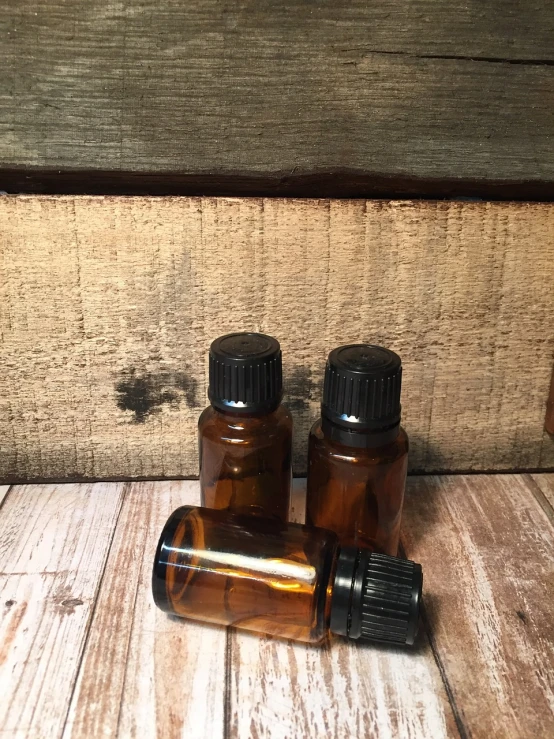 a couple of bottles sitting on top of a wooden table, black fine lines on warm brown, 10 mm, rustic, smelling good