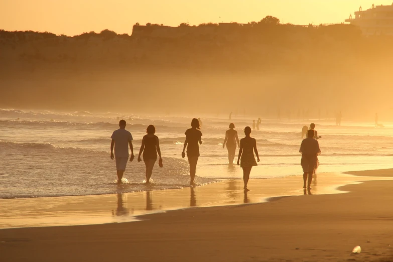 a group of people walking along a beach at sunset, regular sized, lifestyle, on the beach at noonday, motivation