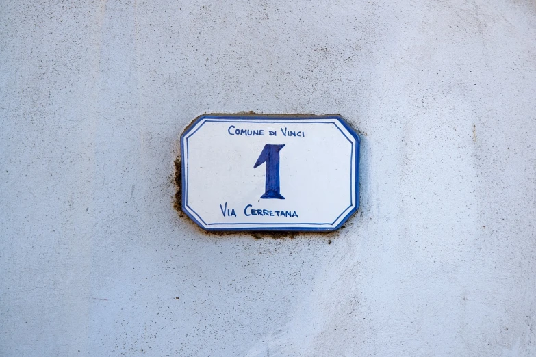 a blue and white sign on a white wall, inspired by Vincenzo Cabianca, renaissance, 1 1 1 1, cobblestone, first place, high angle close up shot