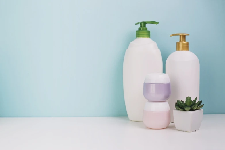 a couple of bottles of lotion sitting on top of a table, a picture, shutterstock, plasticien, on a pale background, banner, product photo, vessels