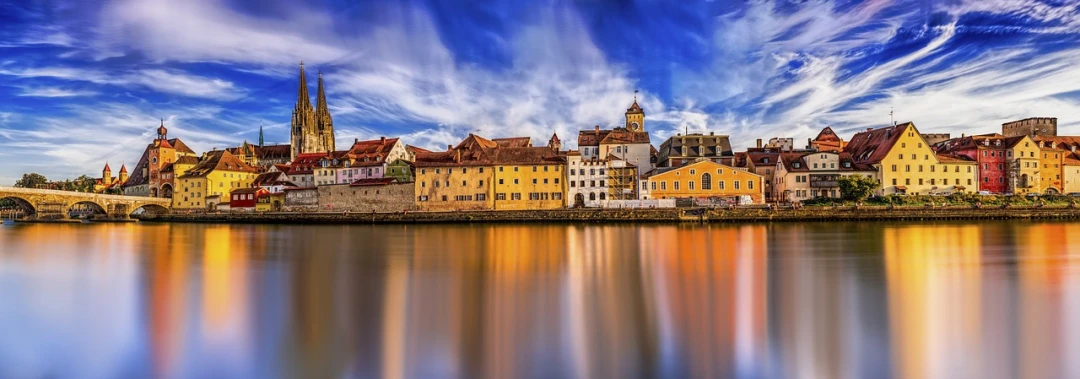 a group of buildings sitting next to a body of water, a picture, by Juergen von Huendeberg, shutterstock, baroque, calm vivid colors, slow exposure hdr 8 k, transylvania, golden glow