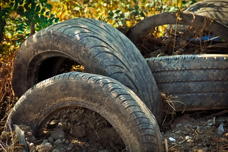 a pile of tires sitting on top of a pile of dirt, a picture, shutterstock, plasticien, photo of poor condition, beautiful surroundings, close - up photo, garner holt