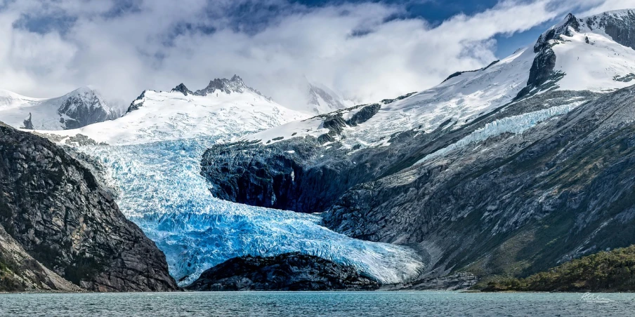 a large glacier in the middle of a large body of water, by Juan Carlos Stekelman, trending on unsplash, profile picture 1024px, hdr photo, ffffound, blue glacier