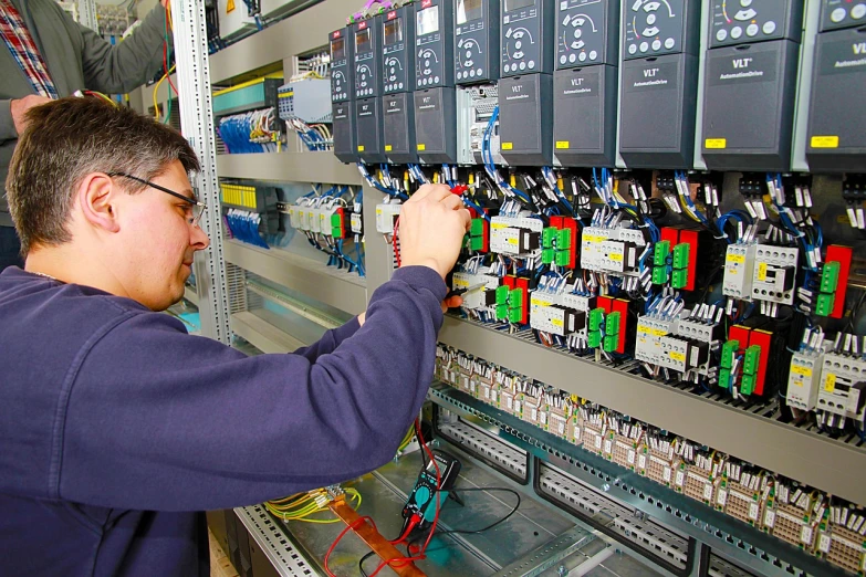 a man working on electrical equipment in a factory, a picture, high res, control panels, future!!, brock hofer
