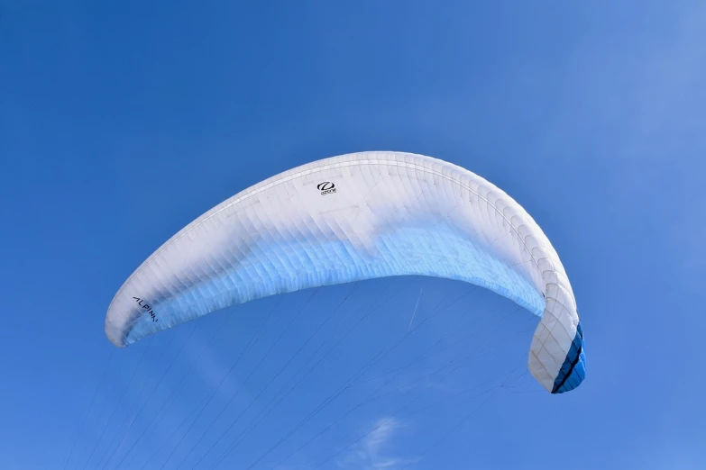 a person is parasailing in the blue sky, by Julian Allen, flickr, blue and white color scheme, white veil, seen from the side, panorama
