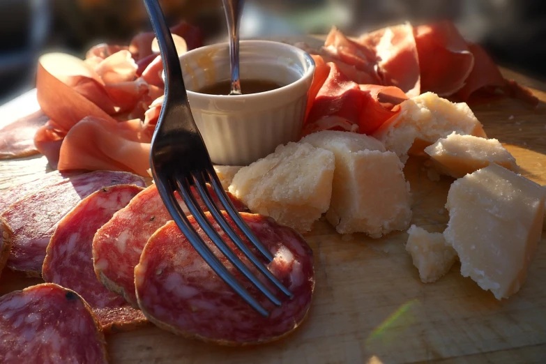 a close up of a plate of food with a fork, by Emiliano Di Cavalcanti, pexels, dau-al-set, salami, oversaturated, late afternoon, cheeses