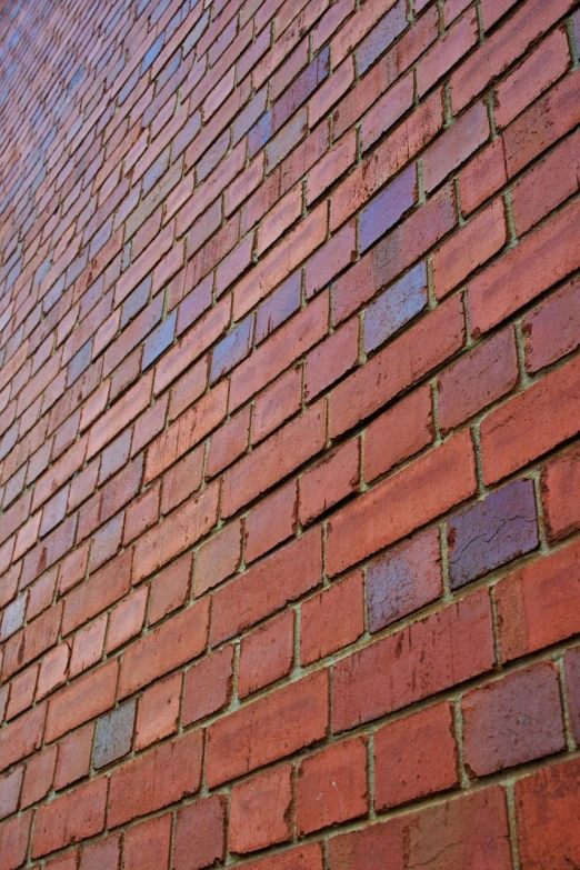 a red brick wall with a blue sky in the background, a picture, modernism, detailed zoom photo, outdoor photo, angled, construction