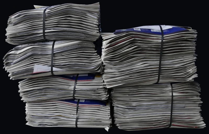 a stack of newspapers sitting on top of each other, a portrait, by John Murdoch, private press, on black background, clean long lines, gettyimages, hay