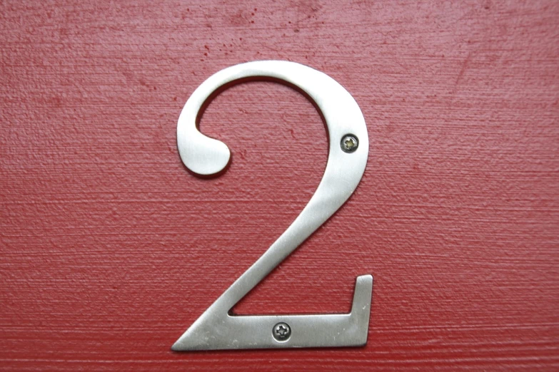 a close up of a number two on a red door, a stock photo, by Edward Corbett, made out of shiny silver, without duplication content, accurately portrayed, information